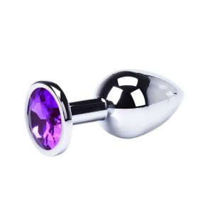 Joyas anales metálicas con gema morada reluciente.